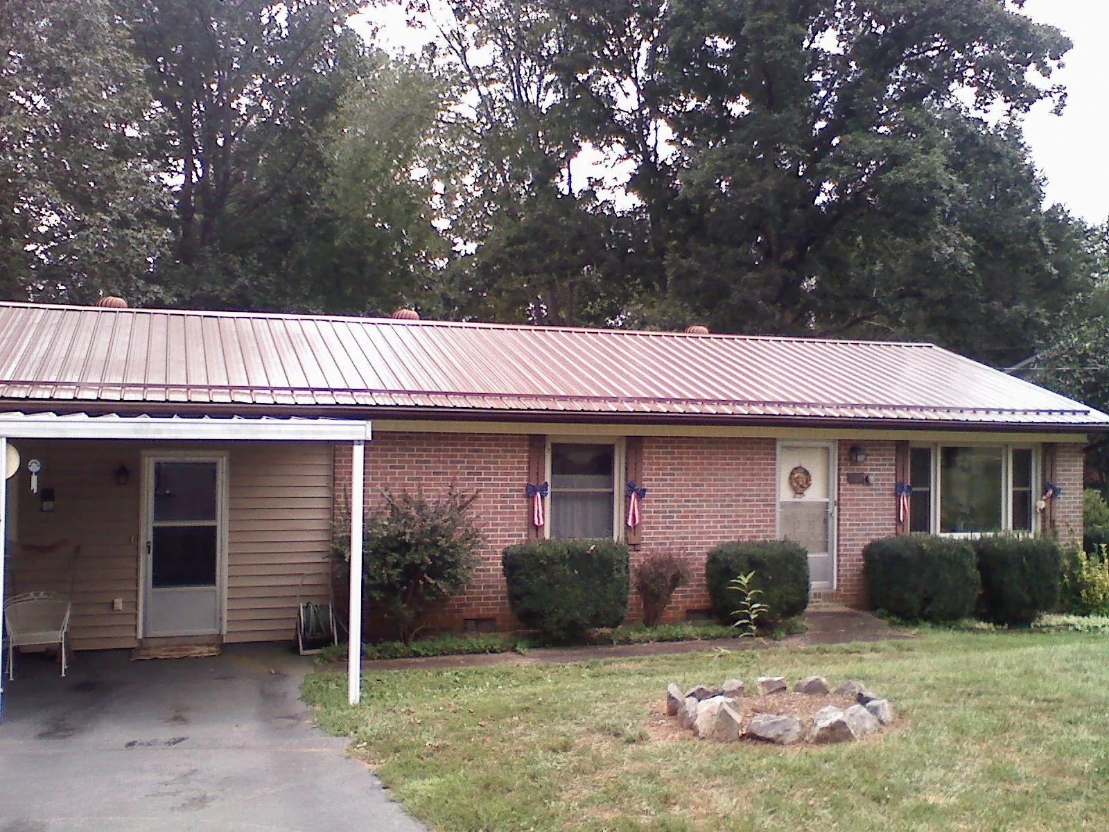 Bronze metal roof and carport on a brick ranch home — Roof Repair work by our crew in Grand River